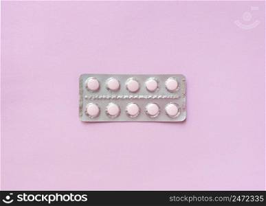 A blister of soft pink pills in the middle on pink background. Monochrome simple flat lay with pastel texture. Medical concept. Stock photography.. A blister of soft pink pills in the middle on pink background. Monochrome simple flat lay with pastel texture. Medical concept. Stock photo.