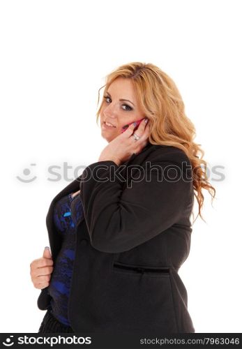 A blond plus size business woman in a black jacket calling on her cellphone, standing in profile isolated for white background.