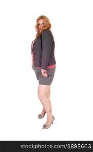 A blond plus size woman in a gray jacket and shorts standing in highheels isolated for white background.