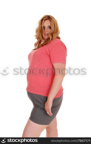 A blond plus size woman standing in shorts and a pink sweater,isolated for white background.