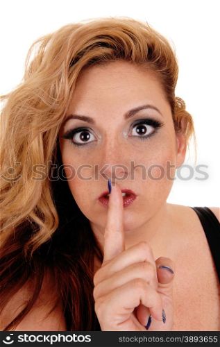 A blond pretty woman with big eye&rsquo;s holding her finger over her mouthbe quiet, isolated for white background.
