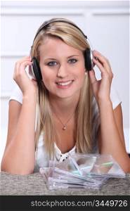 A blond woman, smiling at us, with CDs in front of her.