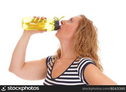 A blond woman standing in profile in exercising clothing drinking from her water bottle, isolated for white background.
