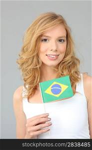 a blonde woman showing a Brazilian flag