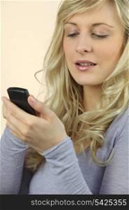a blonde woman watching her cell phone