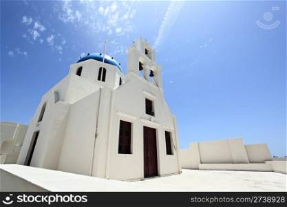 A blue domed orthodox church against a clear blue sky. Oia village, Santorini island, Greece. Low angle view.. Santorini orthodox church