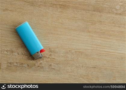 A blue lighter isolated on a wooden background