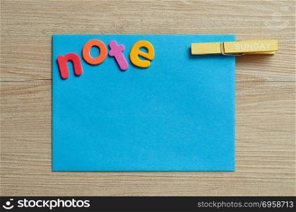 A blue note with the word note with a peg with the word sunday on it