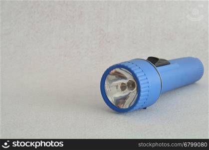A blue plastic flashlight isolated against a white background