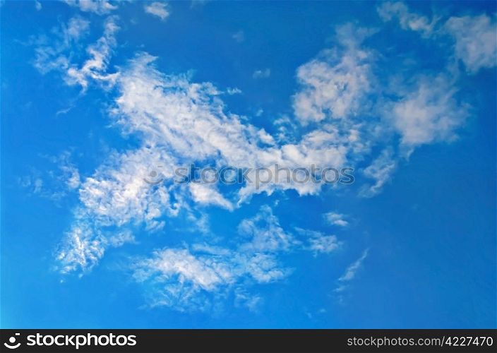 A blue sky with feathery white clouds