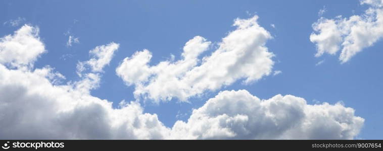 A blue sky with lots of white clouds of different sizes