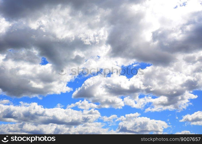 A blue sky with lots of white clouds of different sizes