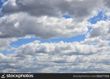 A blue sky with lots of white clouds of different sizes