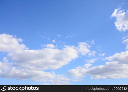 A blue sky with lots of white clouds of different sizes