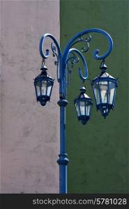 a blue street lamp and a green white wall in la boca buenos aires argentina