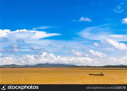 A boat in river that changed to yellow color during rainy season, Trat, Thailand