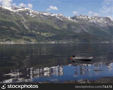 a boat in the fjord in norway with mountains as background