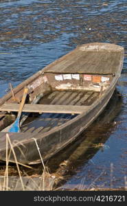 a boat which is frozen in the lake with a meditative beautiful mood in a romantic winter landscape