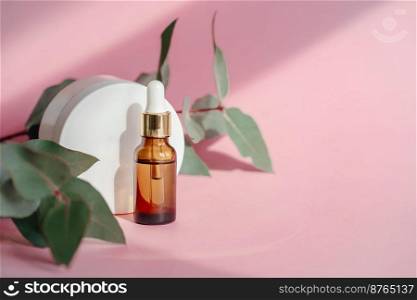 A bottle of cosmetic oil and a white jar of cream stand on a pink background, flooded with sunlight. Nearby lies greenery.. A bottle of cosmetic oil and cream stand on a pink background.