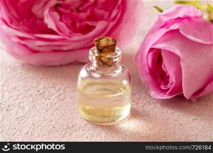 A bottle of essential oil with fresh rose de mai flowers