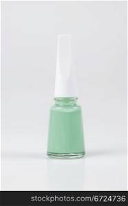 a bottle of green nail polish on white background
