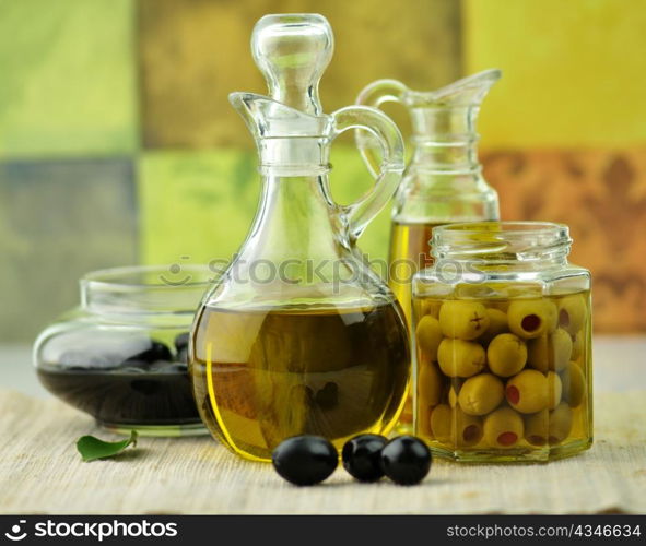 A bottle of olive oil with black and green olives