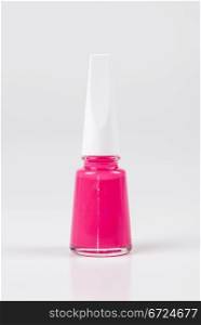 a bottle of pink nail polish on white background
