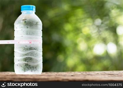 A bottle of water is placed on an old wooden floor, a concept about keeping healthy.