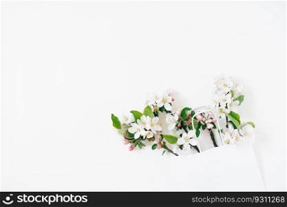 A bouquet of flowering branches of an apple tree in a shopping bag on a white background. Top view Flat lay Copy space. Spring discount concept. Seasonal sale.