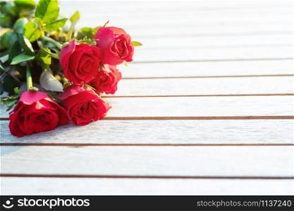 A bouquet of fresh red roses flower nature beautiful flowers on the wooden vintage table Morning sunlight. copy space empty write messages in Valentines day, wedding or romantic love concept.