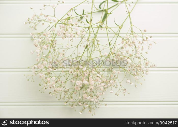 A bouquet of gypsophila flowers lay on the wooden table. Vintage style image. Copy space