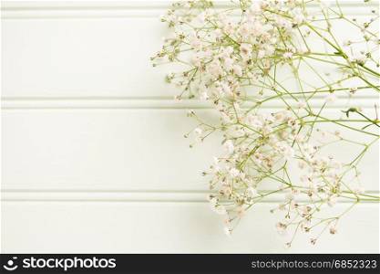 A bouquet of gypsophila flowers lay on the wooden table. Vintage style image. Copy space