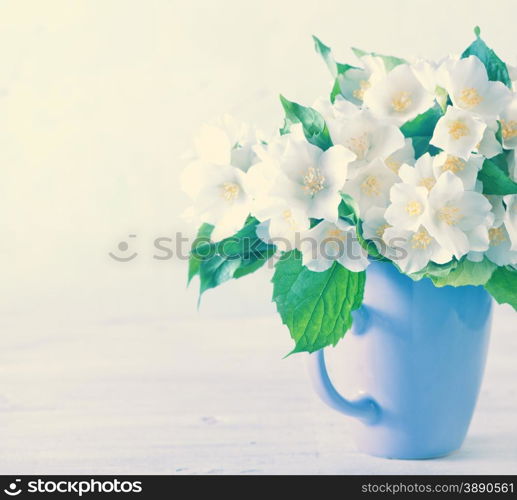 a bouquet of jasmine in a cup on a white table