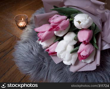 A bouquet of pink and white tulips on the floor