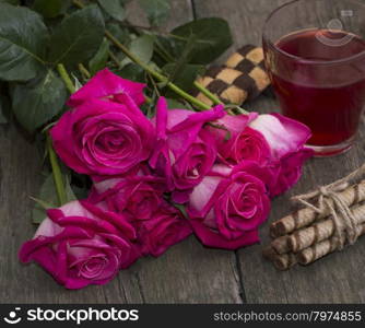 a bouquet of red roses and tea close-up