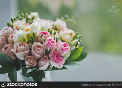A bouquet of small roses on the table in a jug of water.. Wedding bouquet is waiting for its time 675.. Wedding bouquet is waiting for its time 675.