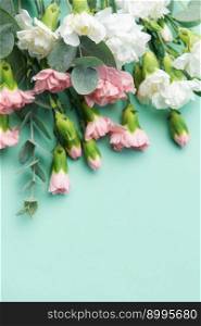A bouquet of white and pink carnations with eucalyptus branches on a soft green background. Festive background.