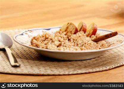 A bowl of apple cinnamon porridge on a wooden table.