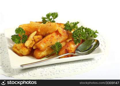 A bowl of honey-glazed roasted parsnips with a serving spoon