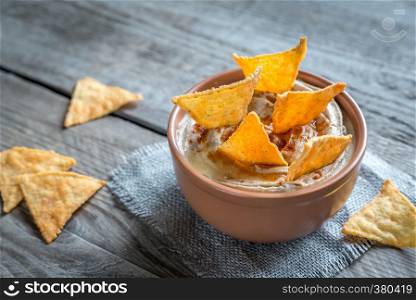 A bowl of hummus with corn chips
