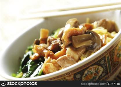 A bowl of noodle with meat and vegetables