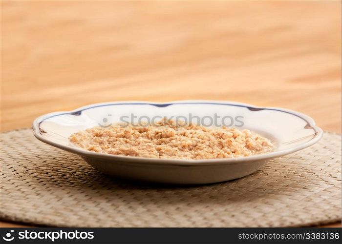 A bowl of porridge on a wooden table.