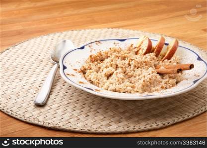 A bowl of porridge with apple and cinnamon spices