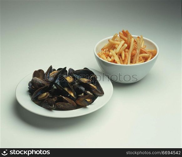 a bowl of seafood and a bowl of chips/fries