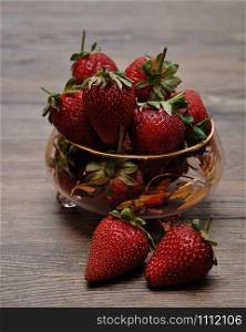 A bowl of strawberries on a wooden background