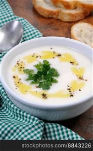 A bowl of white bean puree soup with spicy butter and spices, herb