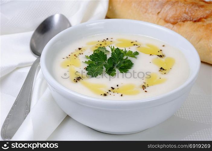 A bowl of white bean puree soup with spicy butter and spices, herb