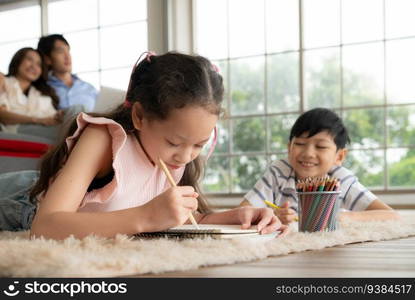 A boy and a daughter from an asian family. The children are having fun in the art of drawing.