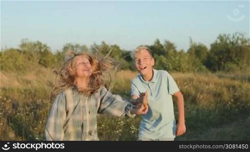 A boy and a girl have launched a kite into the sky and watching joyful