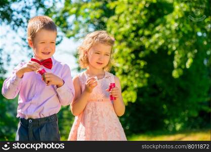 a boy and his girlfriend with soap bubbles in the park